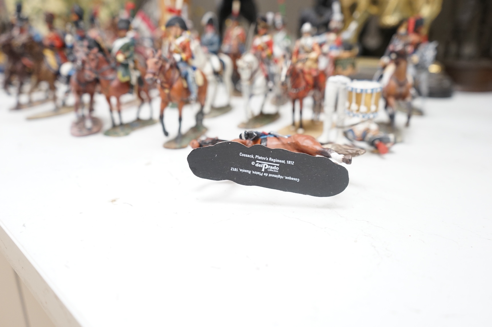 A pair of spelter figures a brass door stop two models of horses two other figures and a large group of toy soldiers. Tallest 45cm.